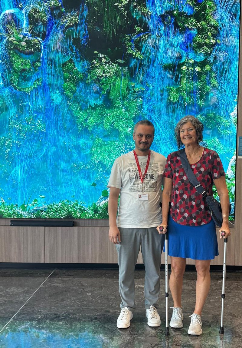 Susan standing with crutches in the hospital lobby in Istanbul, days after her hip replacement